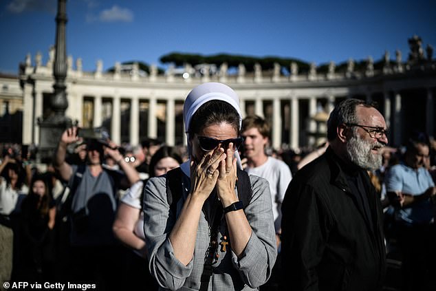 A nun reacts as white smoke (unseen) signals that cardinals elected a new pope during their conclave in the Vatican on May 8