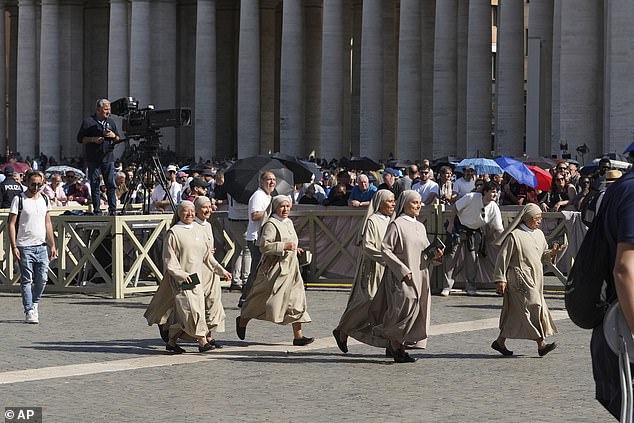 Nuns run to get a position, as the gates open giving access for the public to the front of St. Peter's Basilica