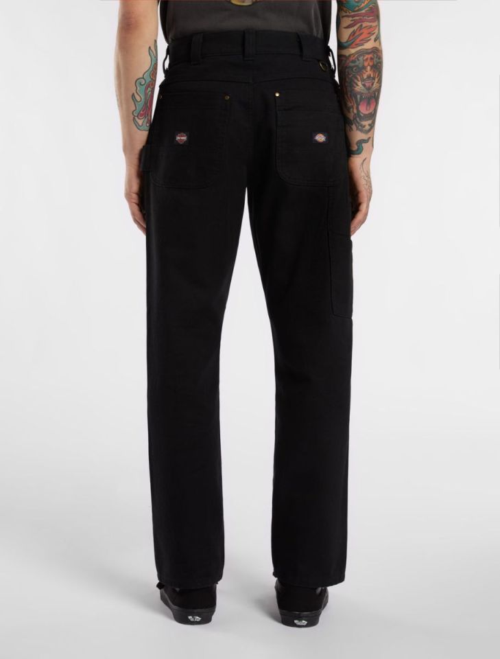 Person wearing black Dickies carpenter pants.