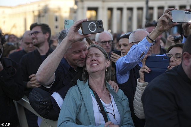 A woman appears emotional as she reacts to the newly elected Pope Leo XIV