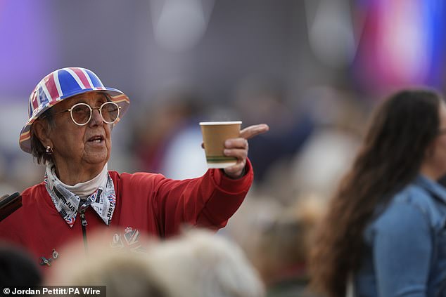 Pictured: A smiling, Union Jack-clad attendee enjoying herself ahead of the concert starting up this evening
