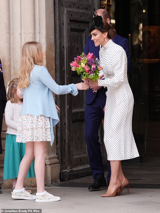 A young girl handed Kate with the bouquet before she laid them down at the Innocent Victims' Memorial