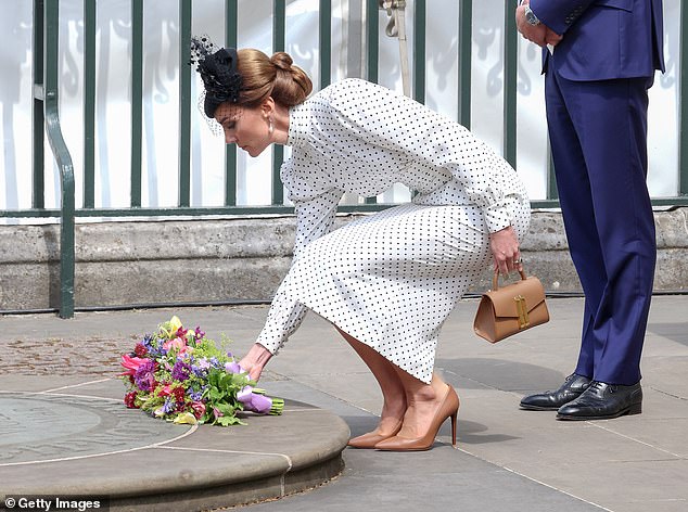 Kate elegantly bent down to lay the posy of flowers at the memorial while flanked by Prince William