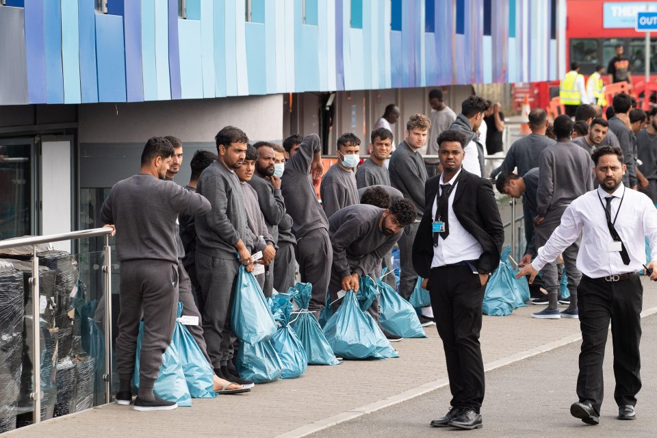 Asylum seekers with luggage outside a hotel in Feltham, UK.