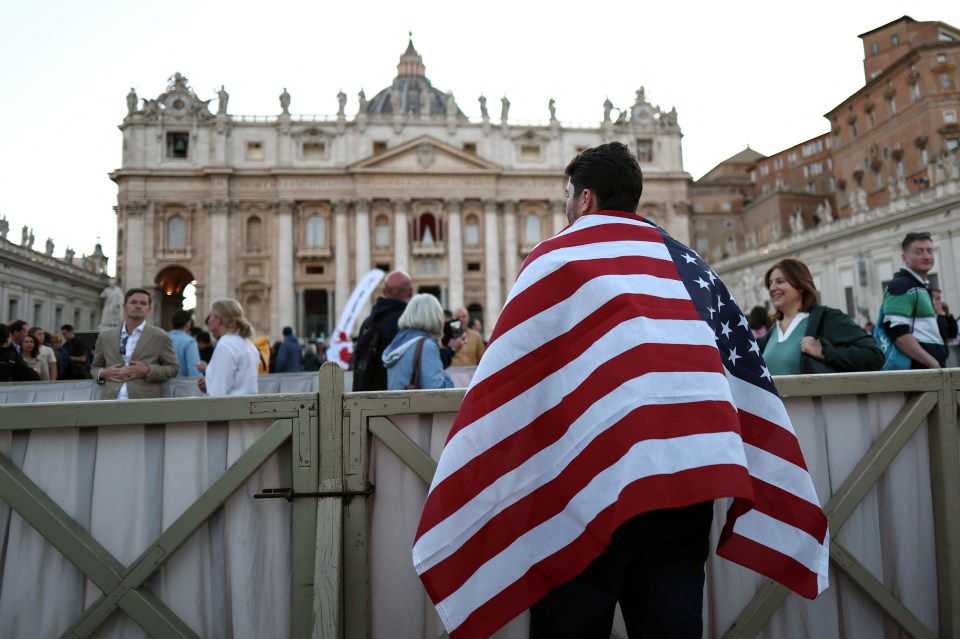Person draped in an American flag in St. Peter's Square.