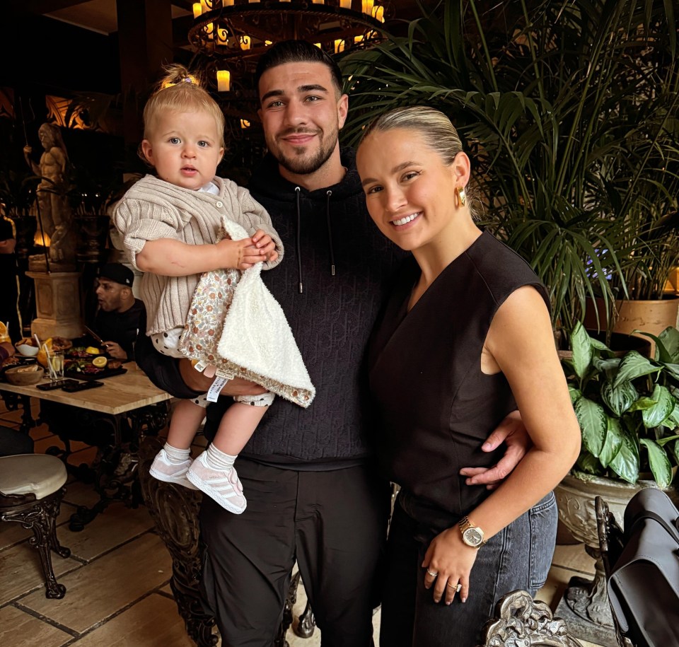 Molly Mae Hague, Tommy Fury, and their baby daughter in a restaurant.