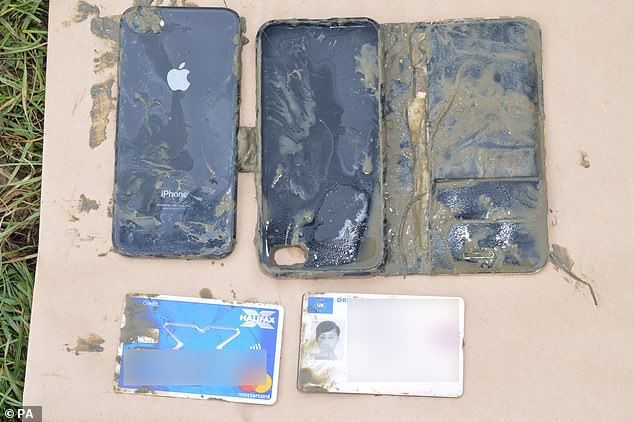 A photo shown to the jury in Danyal Hussein's trial of Bibaa Henry's mobile phone, along with a bank card and a driving licence, which were retrieved from a pond in Fryent Country Park