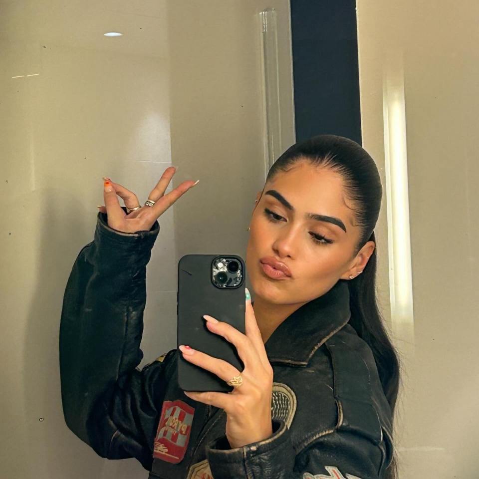 Woman in leather jacket taking a selfie.
