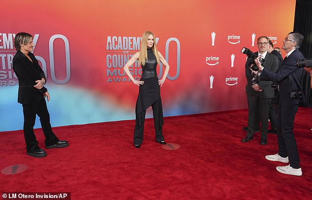 Keith looked every inch the dutiful husband as he stood to the side while his bombshell partner struck a power pose for the paparazzi