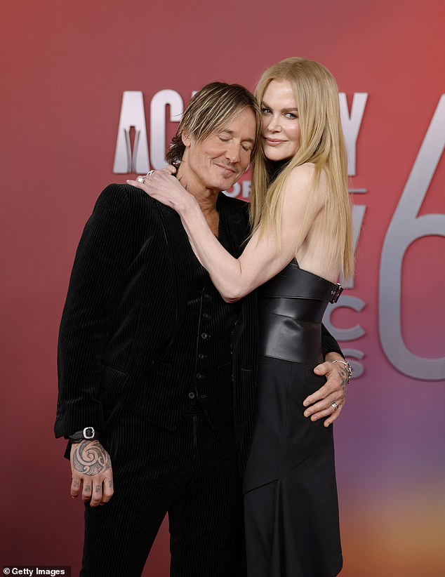 Eventually pulling her hubby in for a cuddle so they could take photos together, Nicole stood proudly beside her husband, who matched her in head-to-toe black