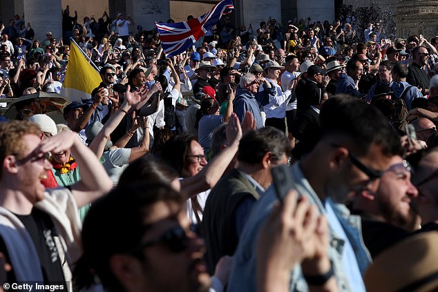 Faithful celebrate on St Peter's Square as they witness white smoke after a new pope is elected at the conclave on May 8, 2025 in Vatican City