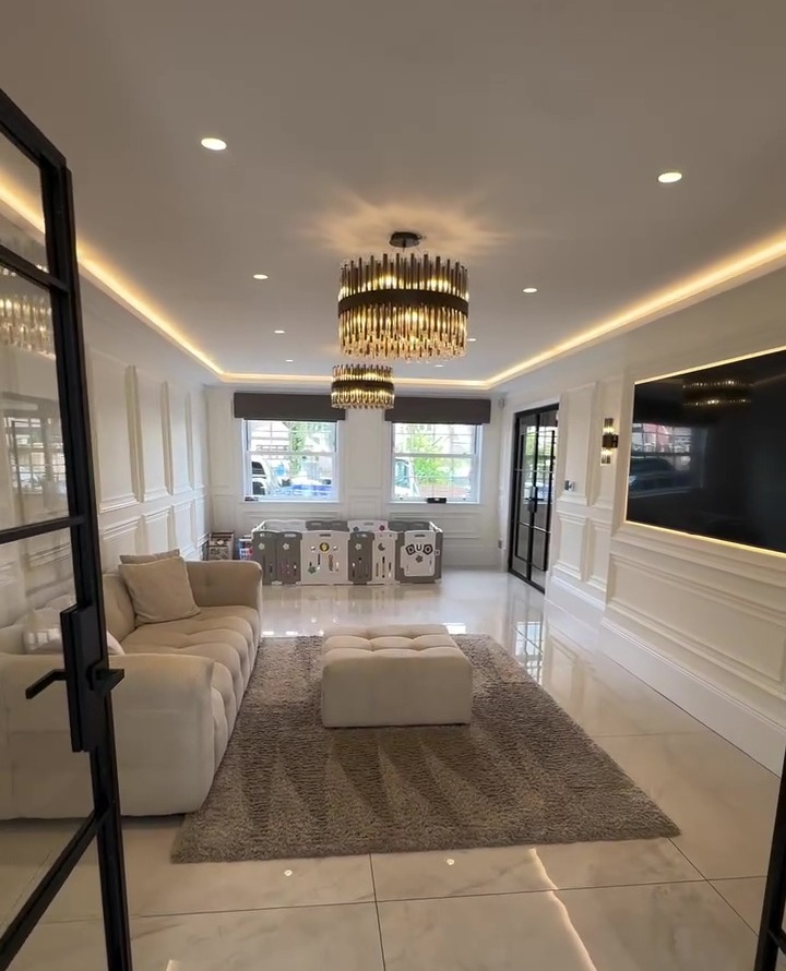 Playroom with beige sofa, light grey rug, and children's play area.