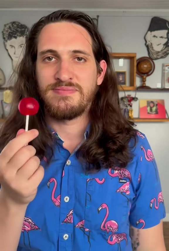 Man holding a red lollipop.