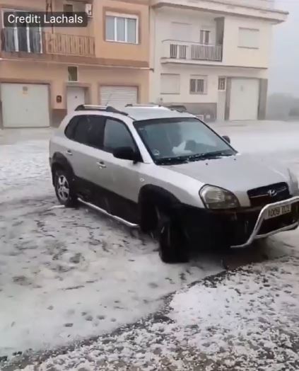 Car covered in hail during a storm in Valencia, Spain.