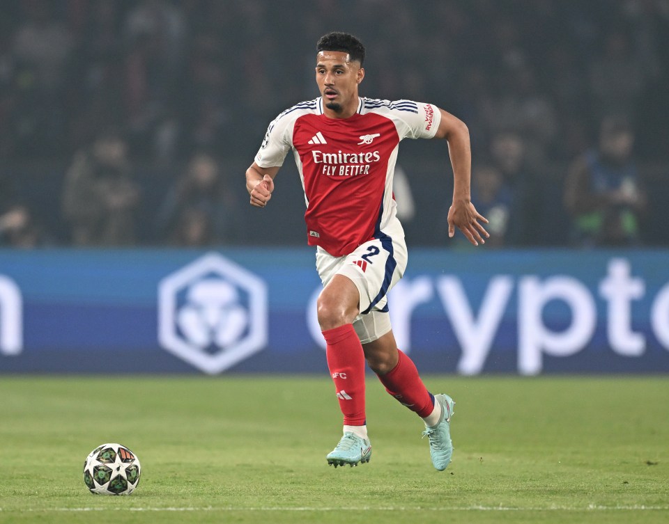 William Saliba of Arsenal running with the ball during a soccer match.