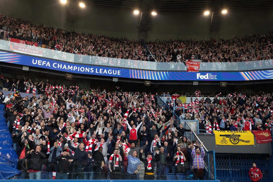 Arsenal fans cheering at a UEFA Champions League match.