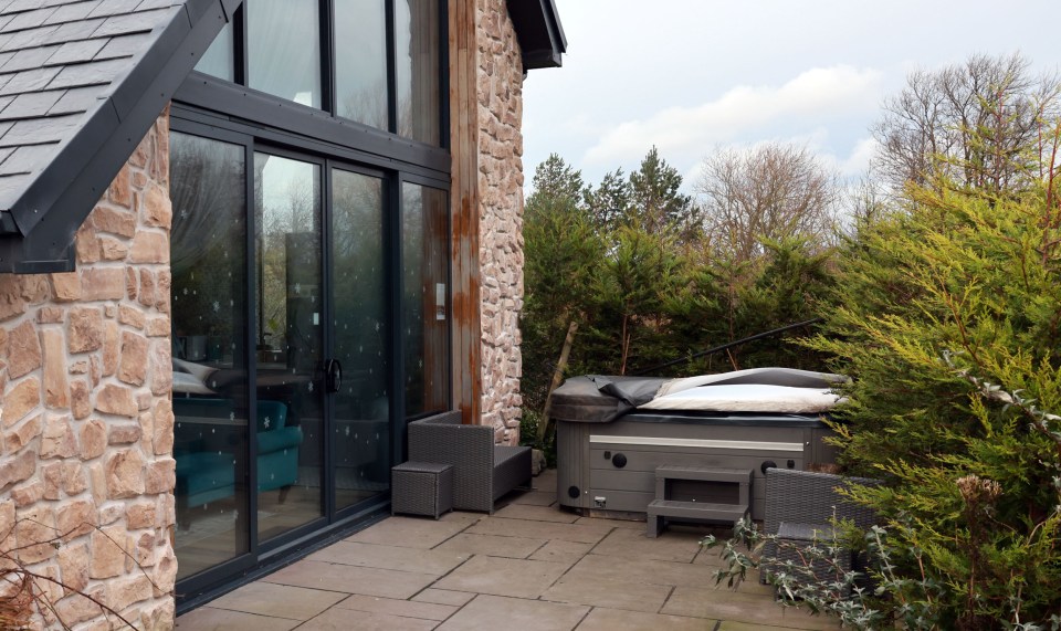 Hot tub outside a stone house.