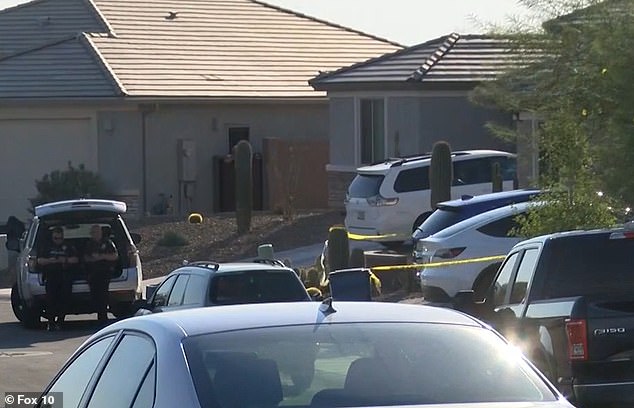 Police outside the house in Marana, north of Tucson, Arizona, on Tuesday evening as they investigated the scene. Parker was left in the blue Honda Acura SUV behind the police tape