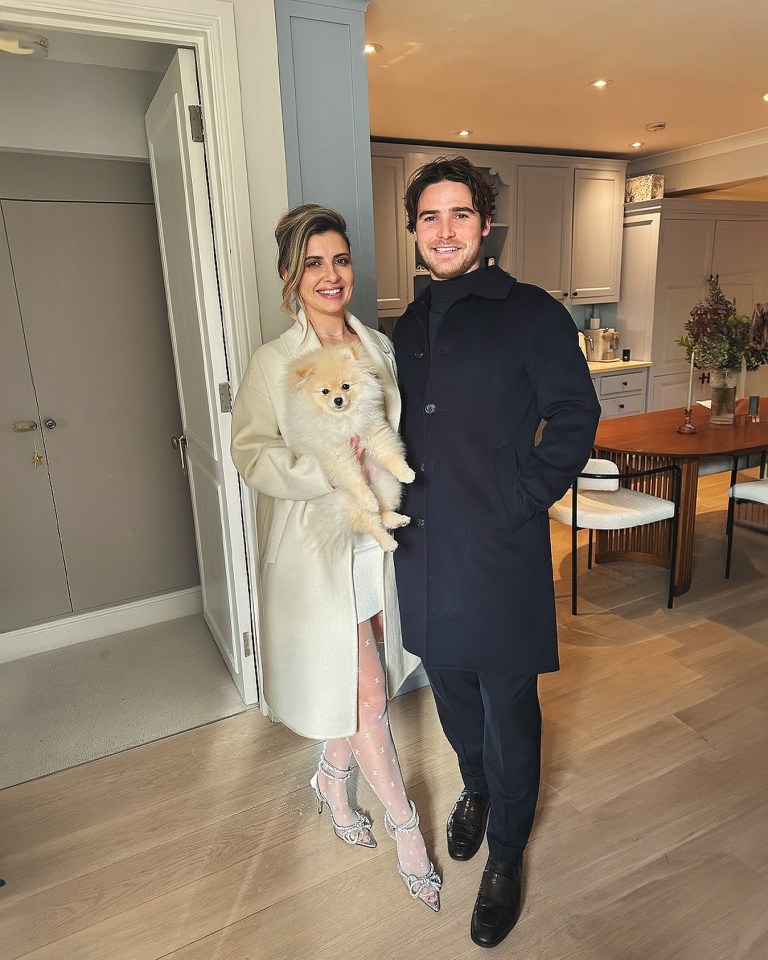 Photo of a couple and their dog in their home.