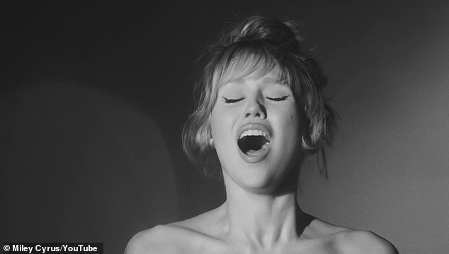 In the middle of the video the Wrecking Ball singer wears a sparkly, strapless gown and at the end of the video she's dressed all in black with a Batman-style head covering