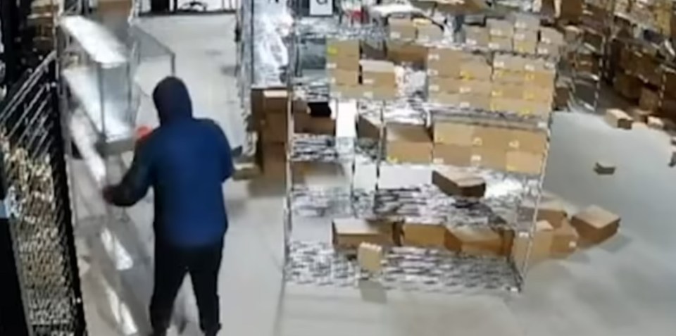 Security footage of a person stealing boxes from a warehouse.