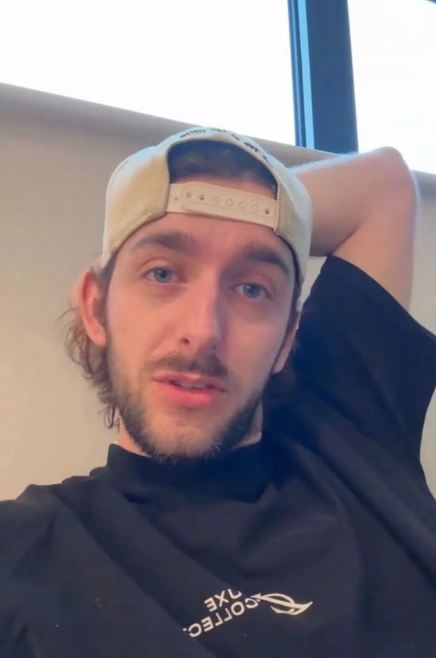 Close-up of a man wearing a baseball cap and black shirt.