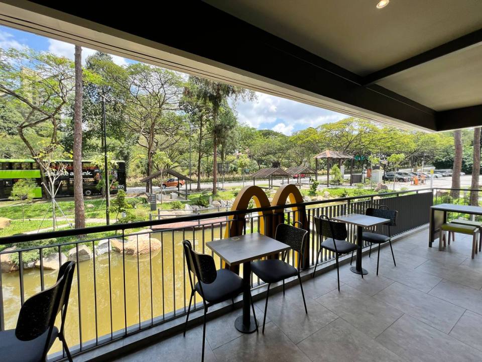 McDonald's patio overlooking a tranquil pond and park.