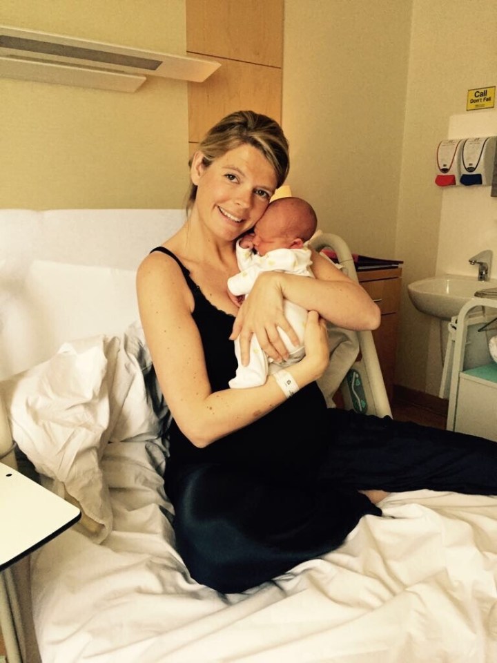 Woman holding newborn baby in hospital bed.