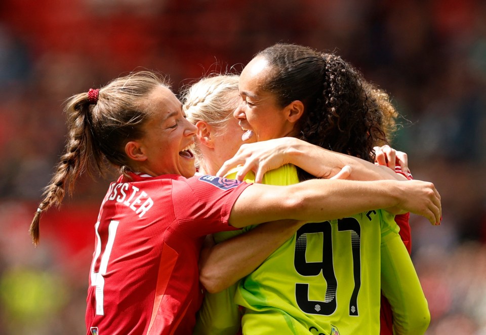 Three Manchester United women's soccer players celebrating a goal.