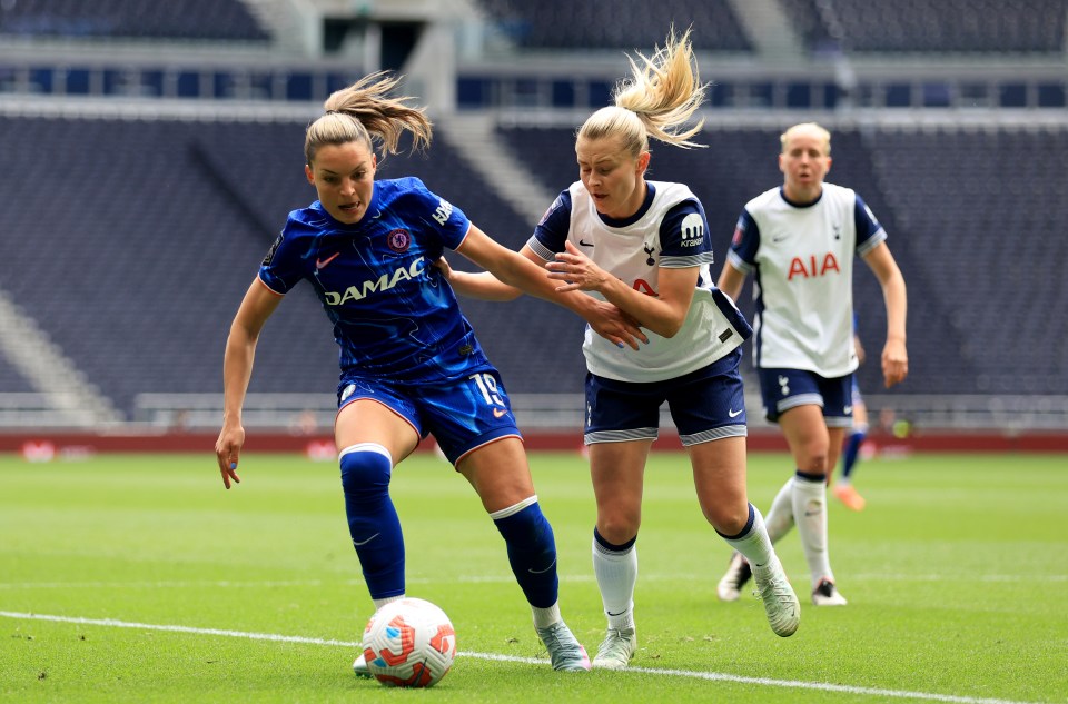 Two female soccer players vying for the ball.