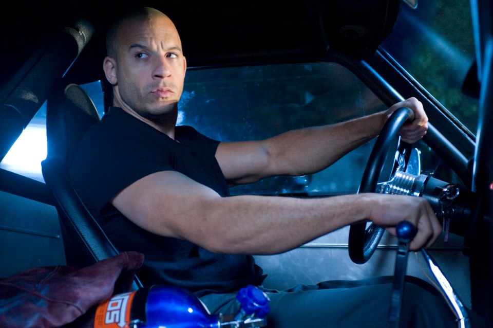 Vin Diesel as Dom Toretto driving a car.