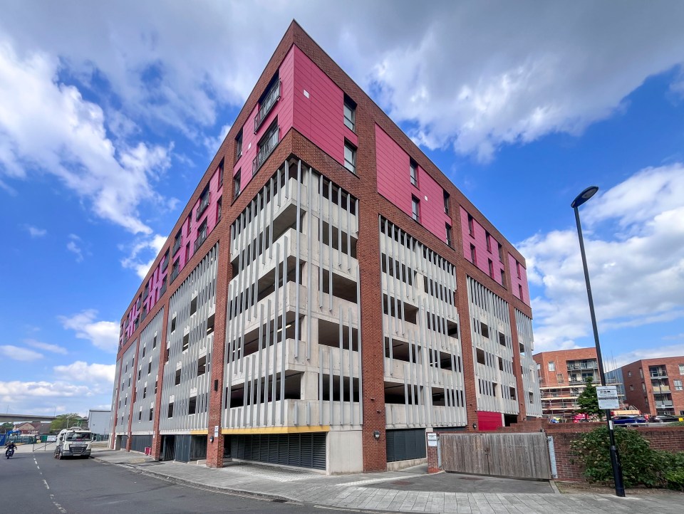 Multi-story parking garage with red brick and concrete exterior.