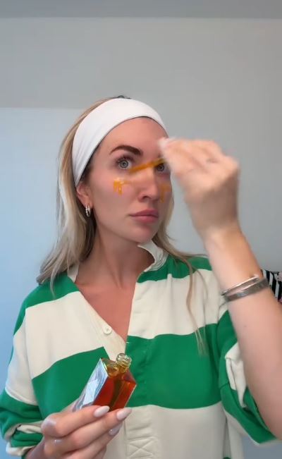 Woman applying face serum.