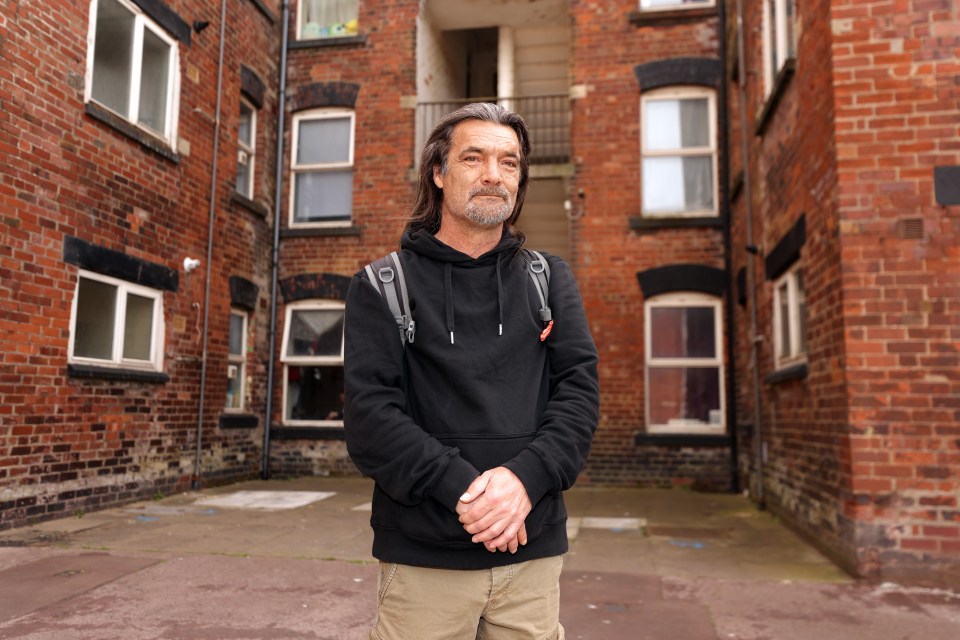 Man standing in a brick courtyard.
