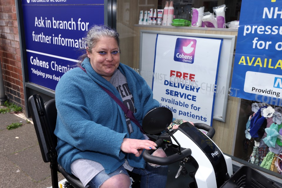 Woman with purple hair operating a mobility scooter.
