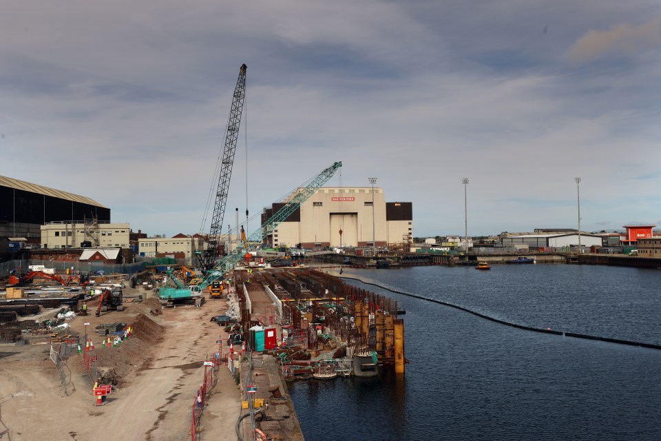 Construction site on Barrow Island, Cumbria, with cranes and a BAE Systems building.