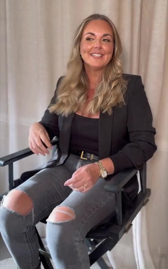 Woman smiling while sitting in a chair.