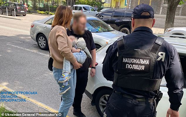 A social worker is seen carrying the child to a waiting car to take the boy into care