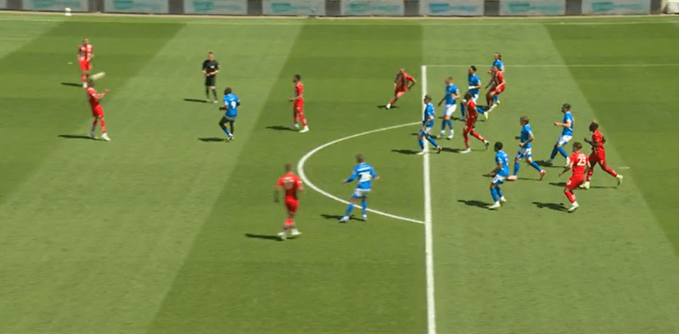 Soccer players in red and blue uniforms during a game.