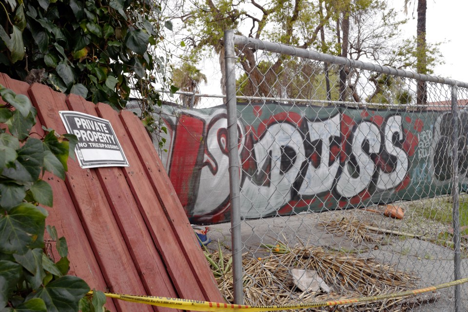 Graffiti-covered fence with "Private Property, No Trespassing" sign.