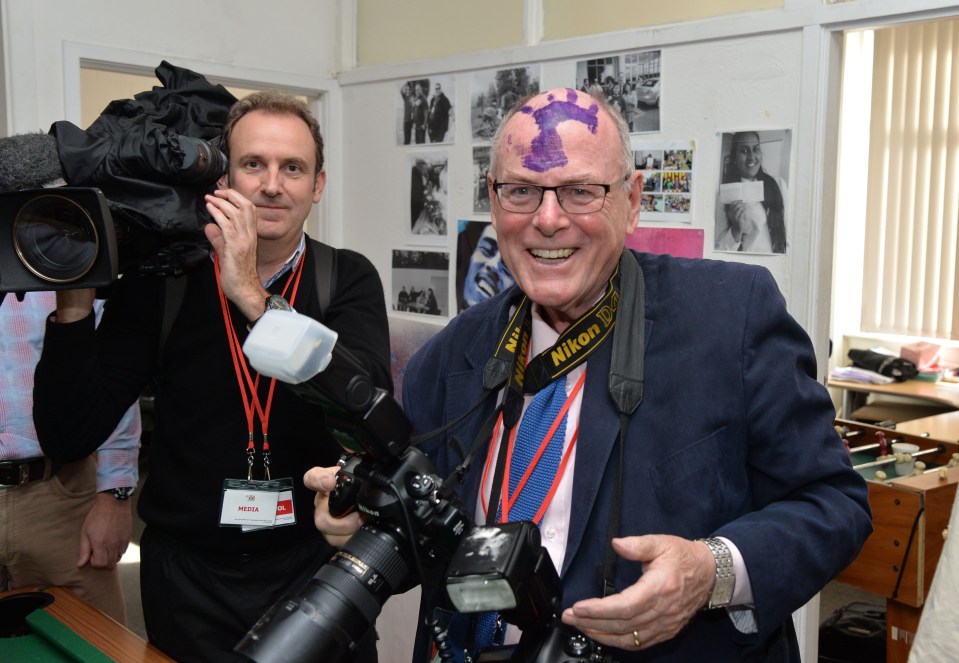 Photographer with a purple handprint on his forehead at a school visit.