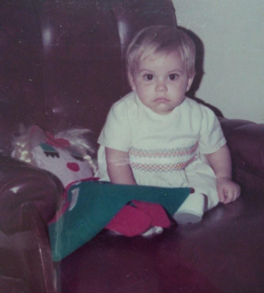Photo of a toddler in a red polka dot dress.