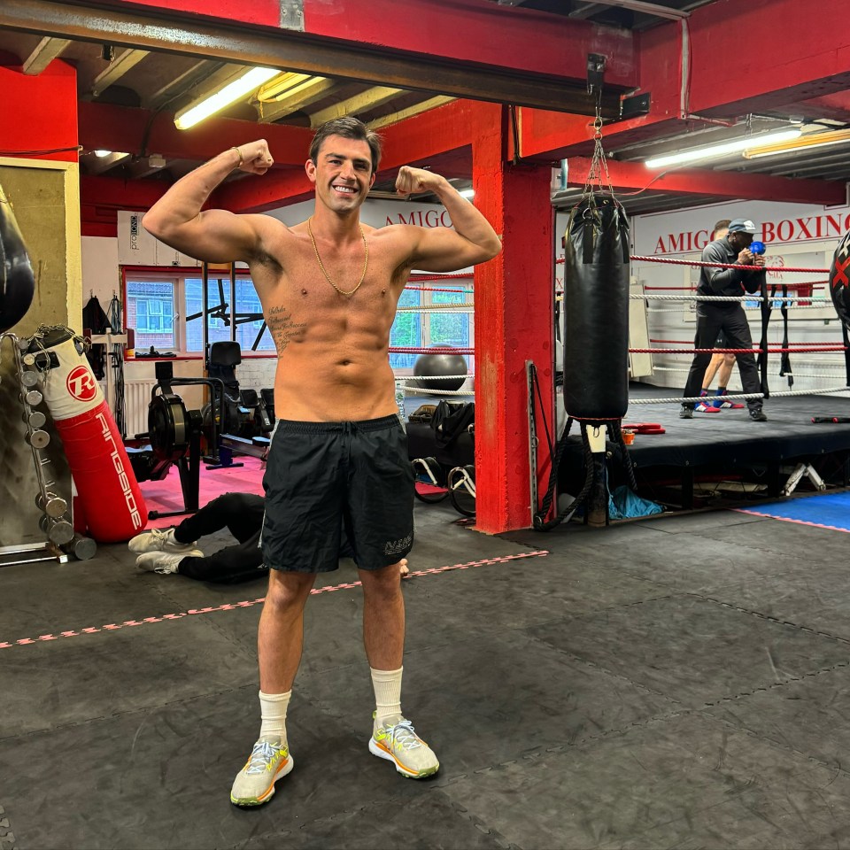 Man flexing in boxing gym.