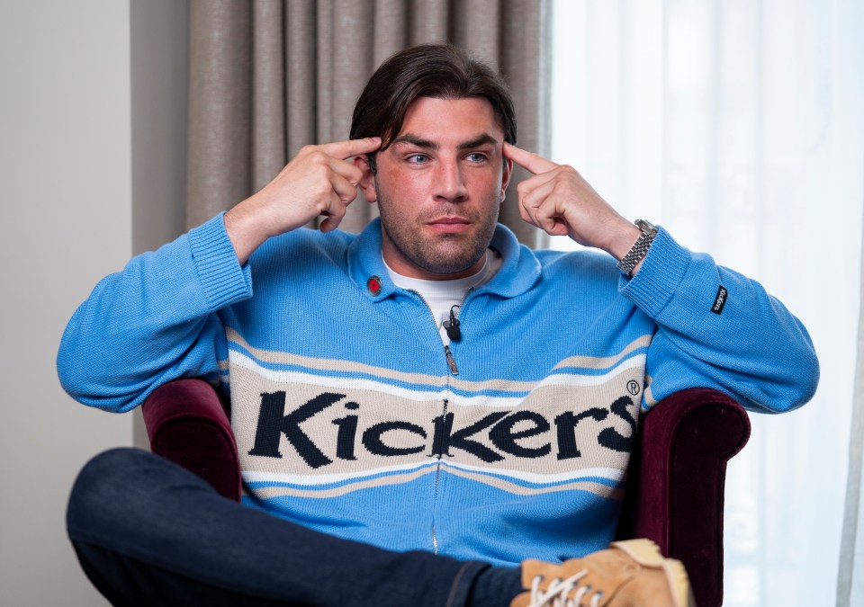 Jack Fincham sits in a chair, touching his temples thoughtfully.