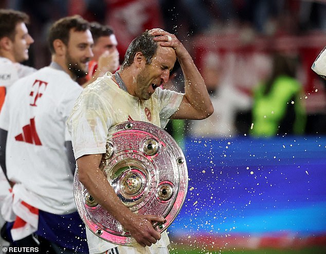 Kane, with trophy in hand, later had alcohol poured over his head in celebration by a team-mate