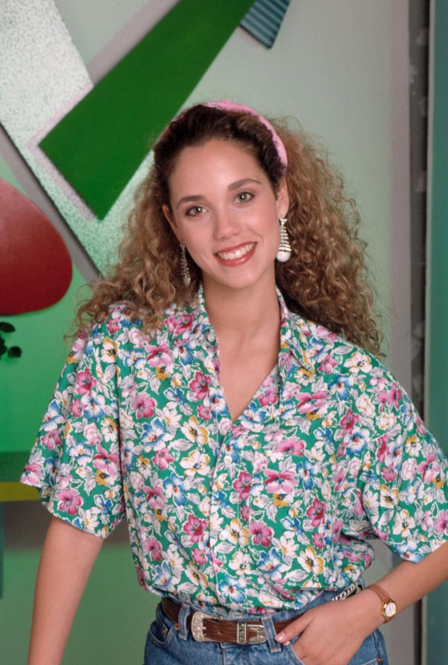 Elizabeth Berkley in a floral shirt and jeans.