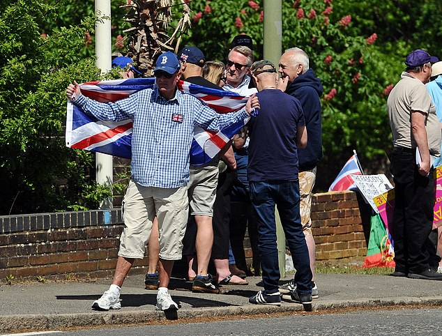 A man carrying a British flag over his shoulders as a group of around 100 people descended on the site