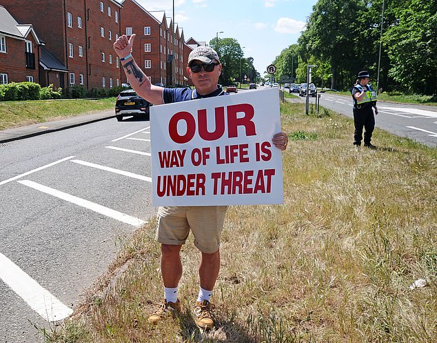 A man from the anti-migration protest held up a sign which read: 'Our way of life is under threat'