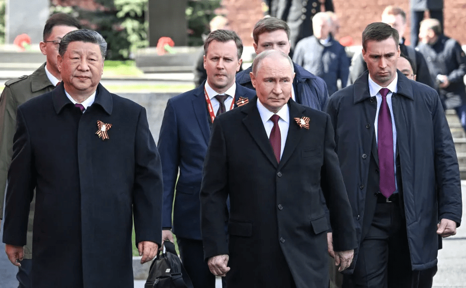 Xi Jinping and Vladimir Putin walking together in a procession.