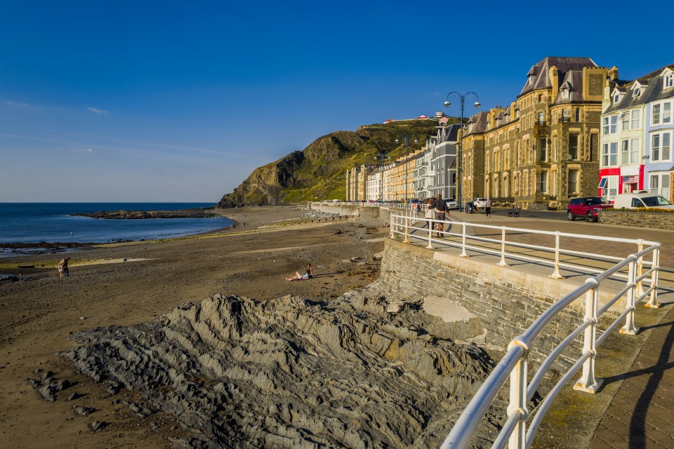 Aberystwyth seaside resort promenade with beach and buildings.